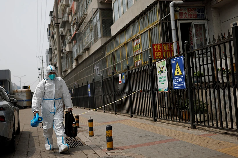 עובד נושא ציוד חיטוי ברחובות השוממים של בייג'ינג בעקבות התפרצות הקורונה