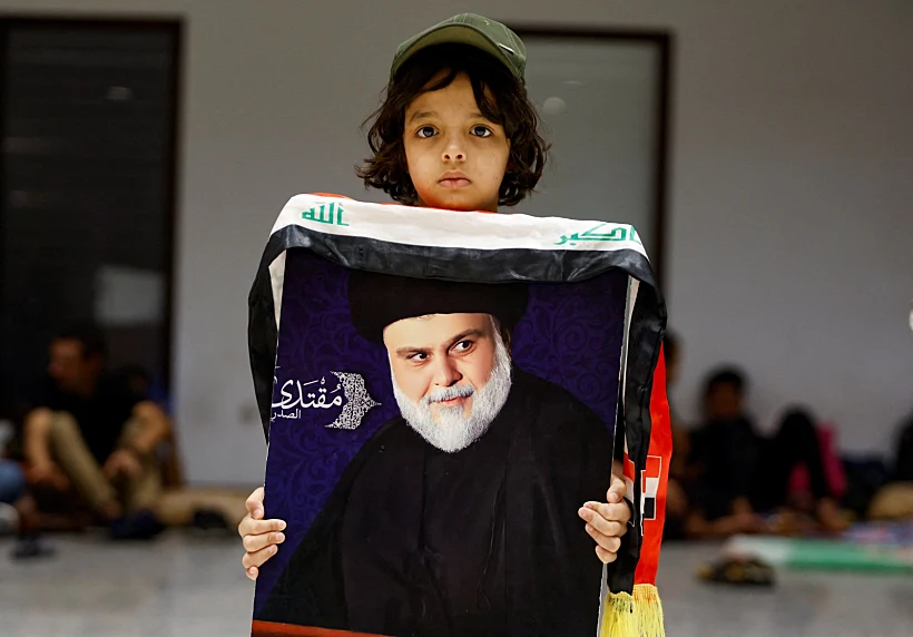 ילד אוחז בתמונה של מוקתדא אלצדר