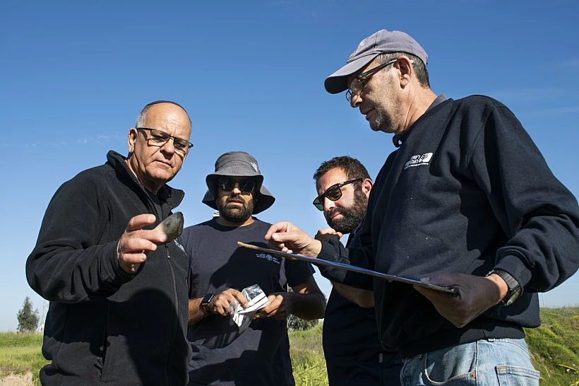 7.מנהל רשות העתיקות אלי אסקוזידו בוחן כלי קיצוץ קדום שהתגלה בחפירה