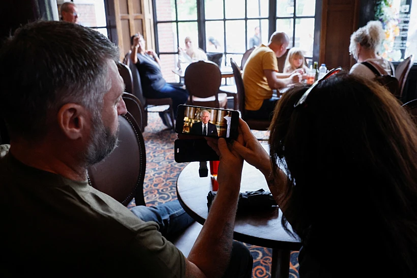 אנגלים בפאב צופים בנאומו של המלך צ'ארלס