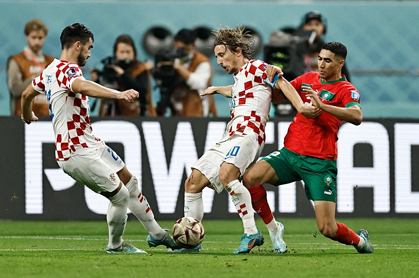 לוקה מודריץ' וג'וזף סוטאלו הקרואטים נאבקים על הכדור מול אשרף חקימי