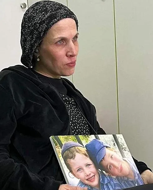 דבורי פאלי מחזיקה את תמונת שני בניה שנרצחו