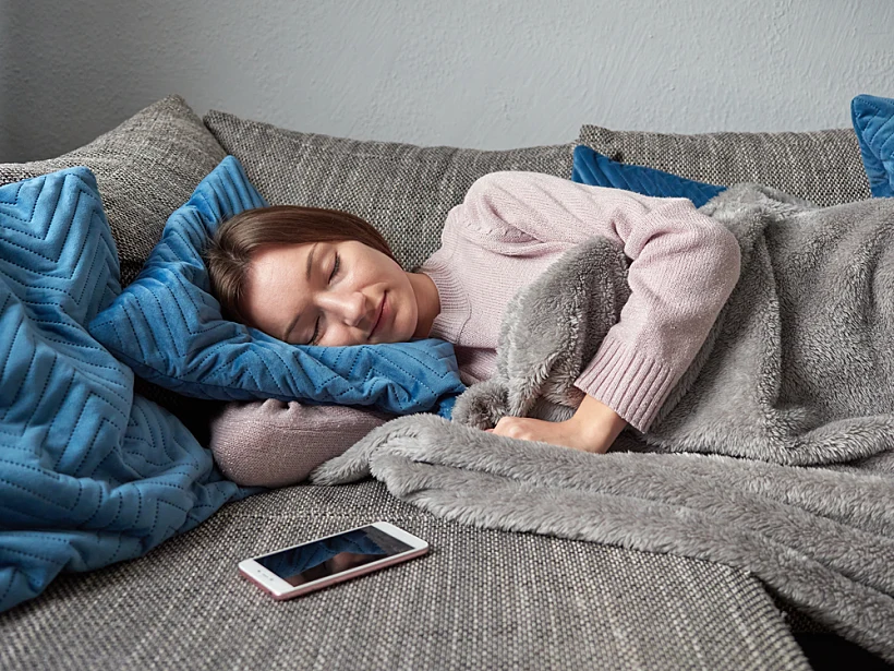 Young,woman,is,taking,an,afternoon,nap,on,the,sofa