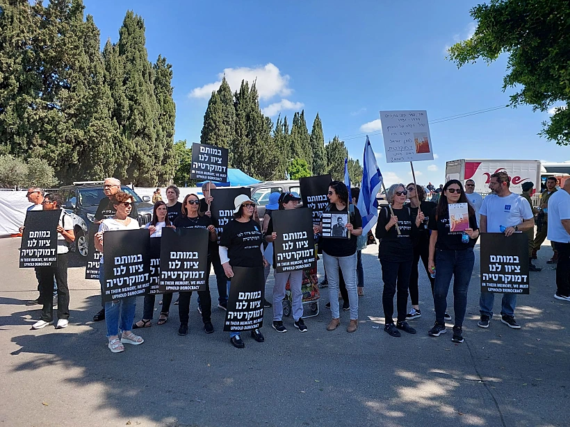 הורים שכולים מוחים בכניסה לבית העלמין הצבאי קרית שאול