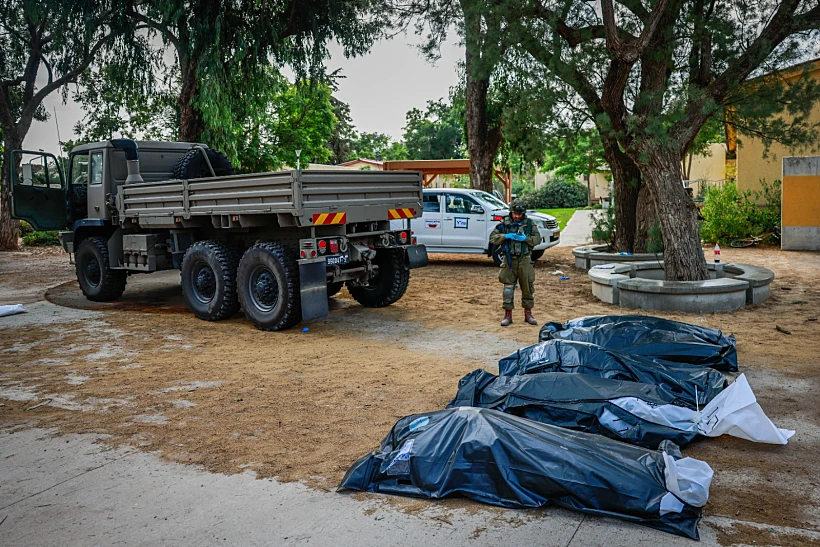 חרבות ברזל עוטף זה חיילי צה"ל מפנים גופות של אזרחים ישראלים בקיבוץ כפר עזה