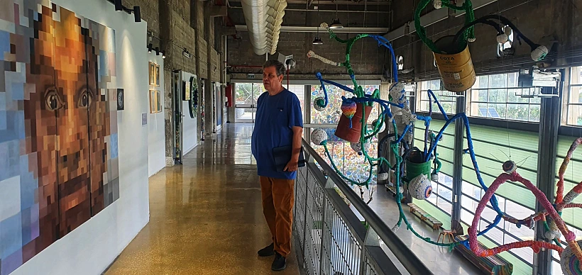 האוצר עדי יקוטיאלי לצד הערוכה תחנת מעבר