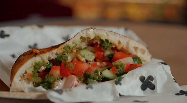 עוף מוקפץ בפיתה עם סלט וטחינה