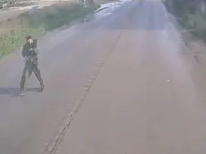 תיעוד: המחבל עומד בצד הכביש ומכוון נשק לאוטובוס