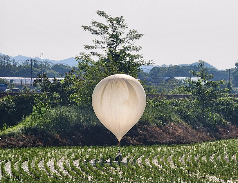 A Balloon Believed To Have Been Sent By North Korea, Carrying Various Objects Including What Appeared To Be Trash And Excrement, Is Seen Over A Rice Field At Cheorwon