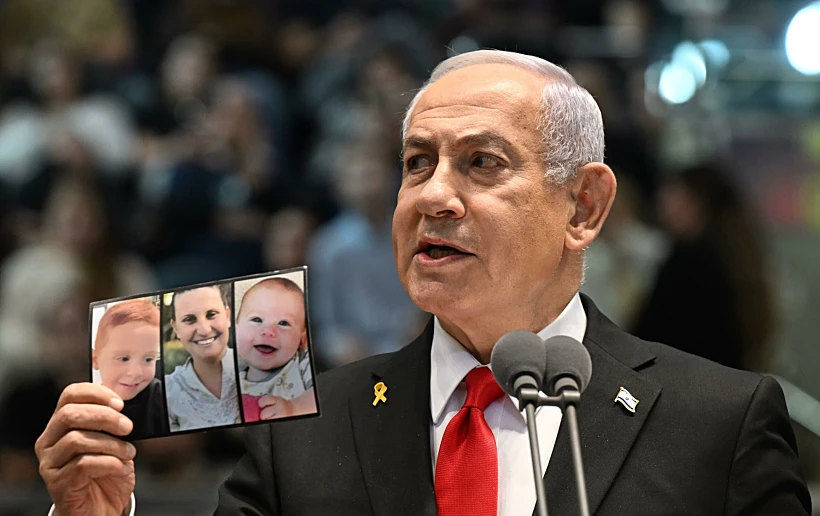 נתניהו מציג את תמונתם של שירי אריאל וכפיר ביבס במהלך נאומו בטקס סיום קורס קצינים
