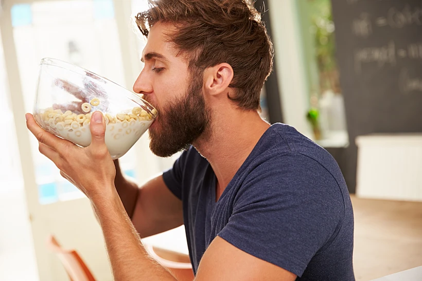 Hungry,young,man,eating,breakfast,from,glass,bowl