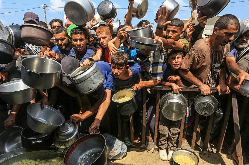 פלסטינים בתור לקבלת מזון בח'אן יונס, דרום רצועת עזה