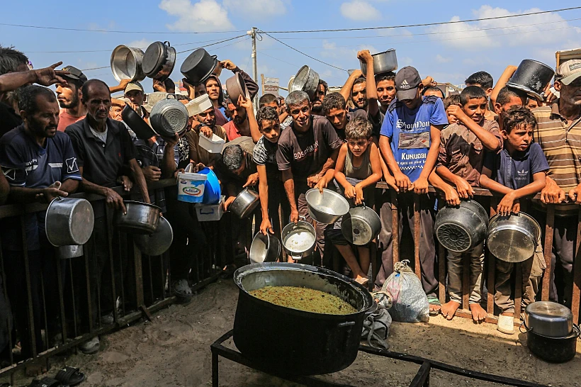 פלסטינים בתור לקבלת מזון בח'אן יונס, דרום רצועת עזה