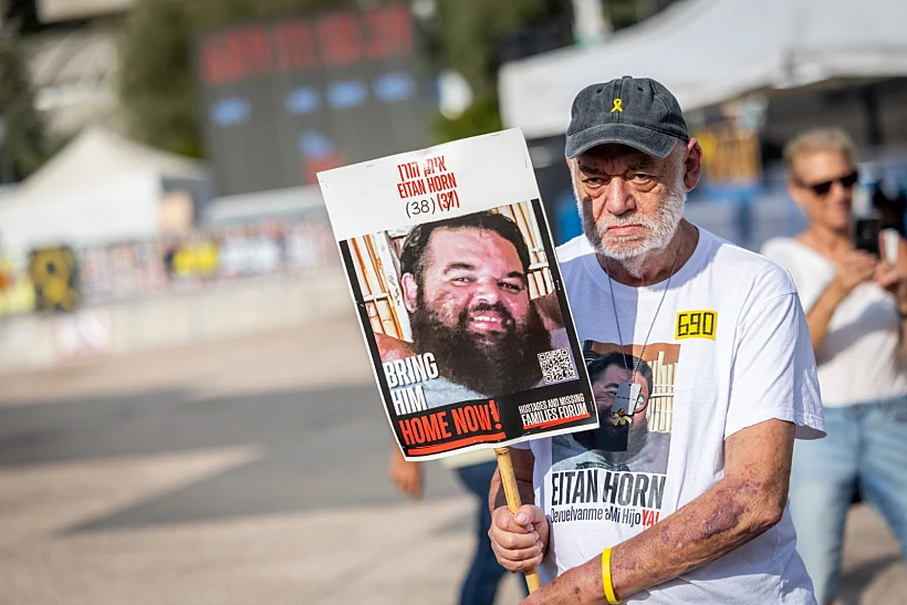 איציק הורן בכיכר החטופים עם תמונת בנו איתן