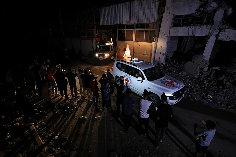 רכבי הצלב האדום עם ארונות החטופים החללים בעזה