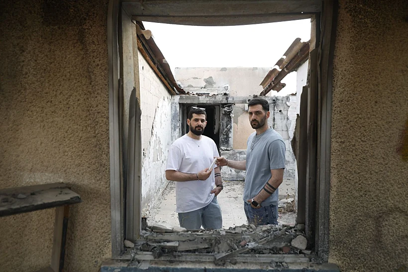 גלי וזיו ברמן בכפר עזה עם המזוזה ששרדה את הטבח