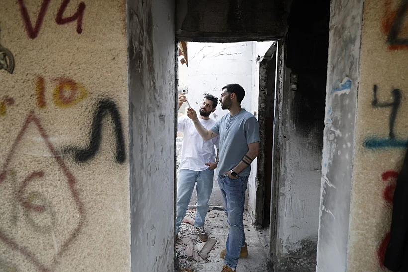 גלי וזיו ברמן בכפר עזה עם המזוזה ששרדה את הטבח