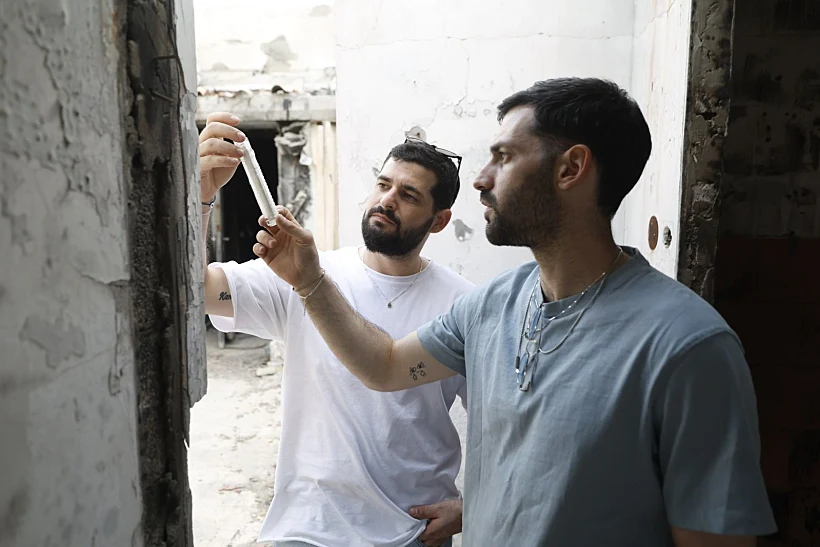 גלי וזיו ברמן בכפר עזה עם המזוזה ששרדה את הטבח