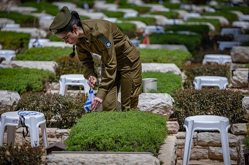 חיילת מניחה דגלי ישראל על קברי חללי צה"ל בהר הרצל