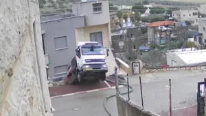 משאית שאבה מים משכונה מוצפת והדרדרה לחצר בית