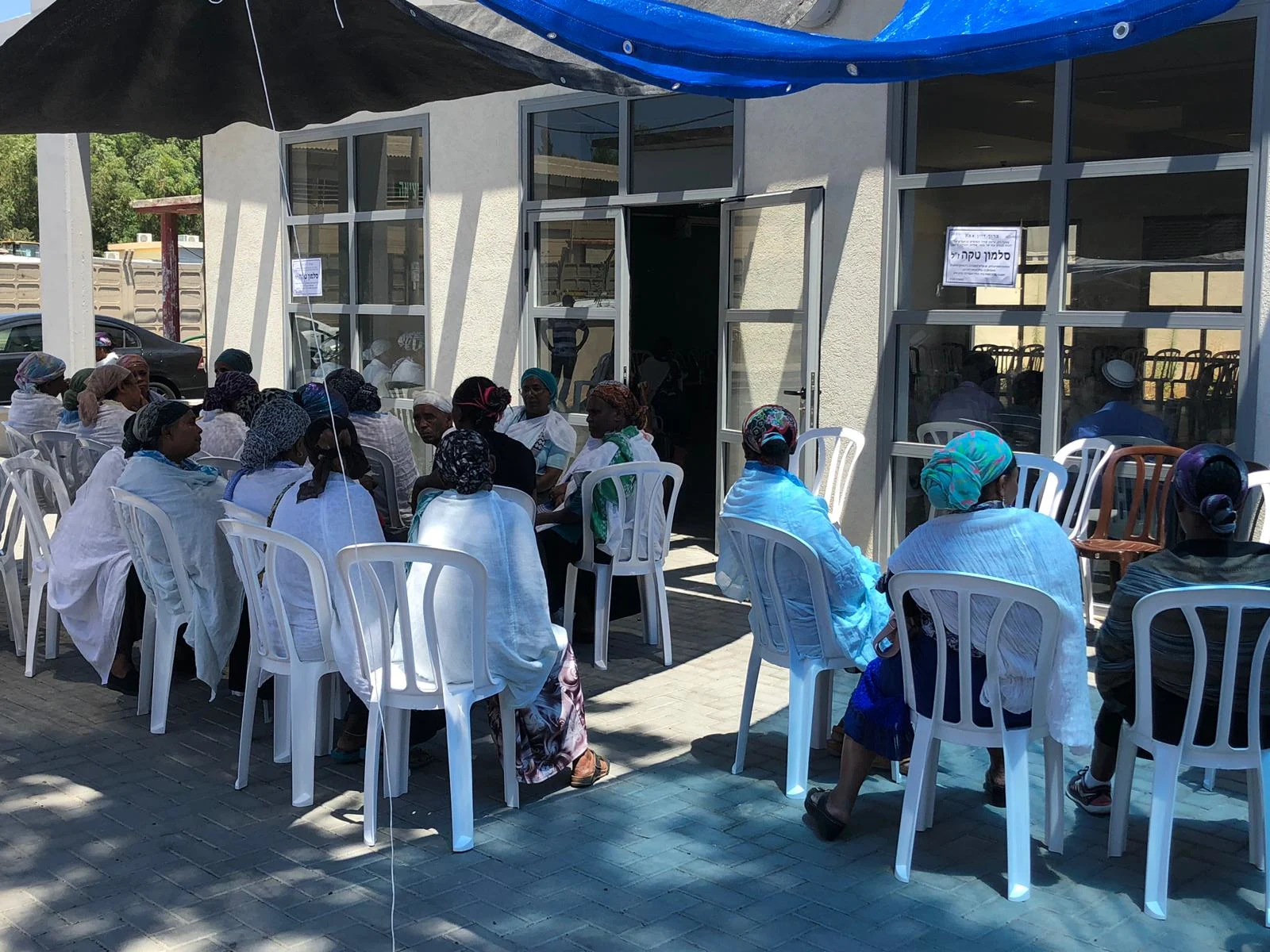 משפחתו של סלמון טקה עם המנחמים בבית הקהילה האתיופית