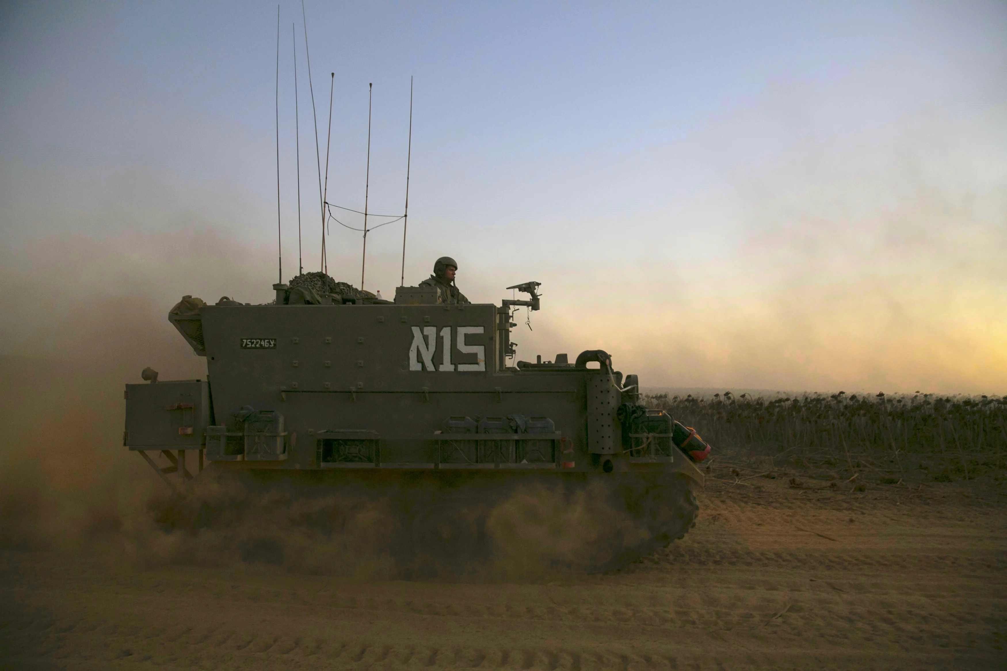 חייל צה''ל על נגמ''ש בשטח כינוס ליד הרצועה במבצע ''צוק איתן''