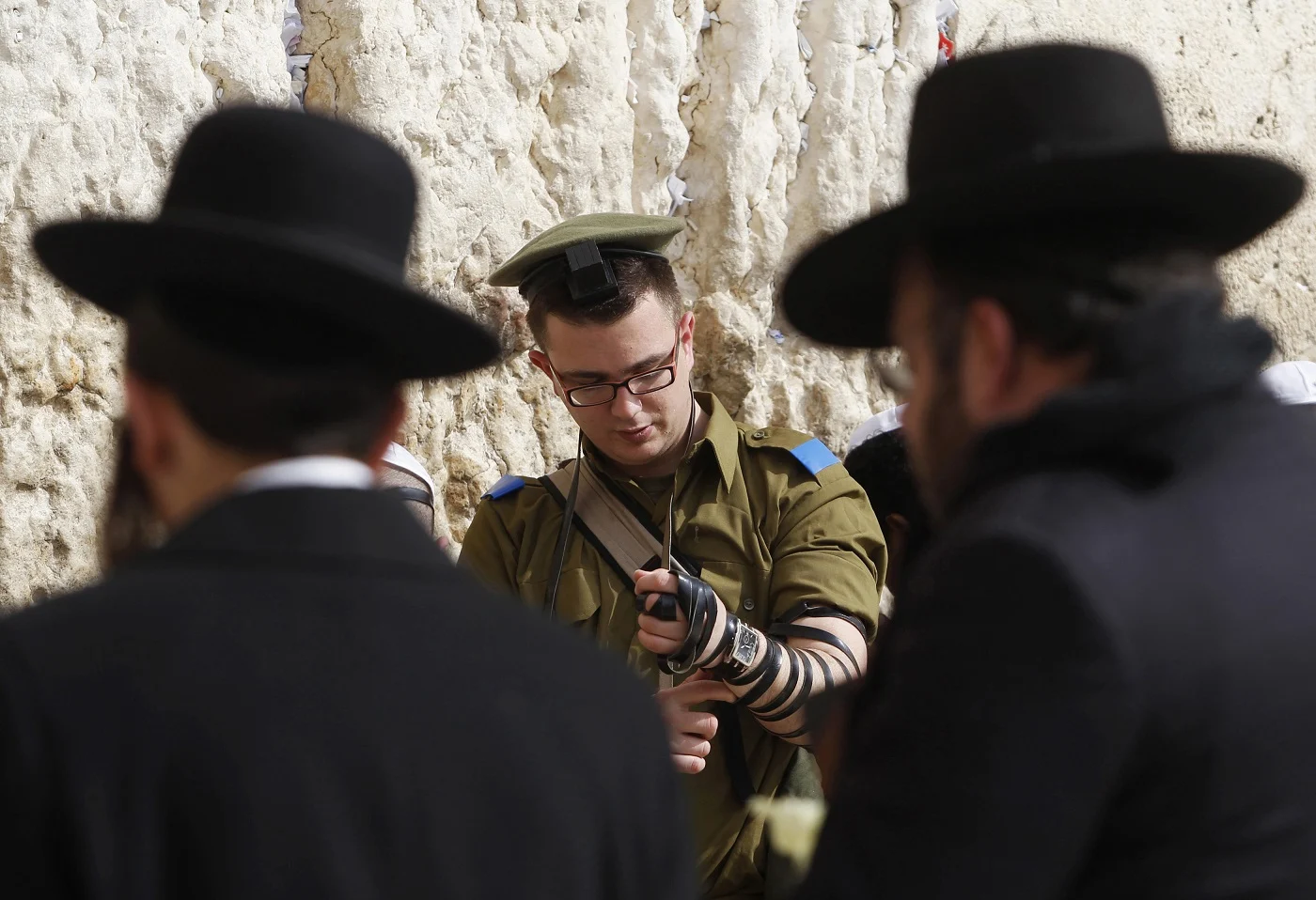 חייל מניח תפילין בכותל