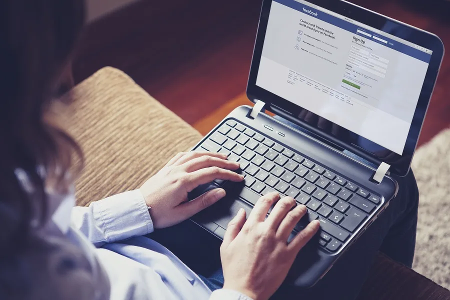 אישה גולשת ברשת החברתית פייסבוק