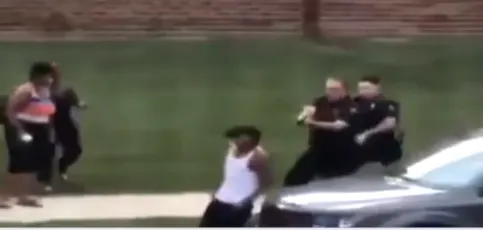 שוטרים לבנים מכוונים נשק לעבר ג'ייקוב בלייק, שניות ספורות לפני שנורה