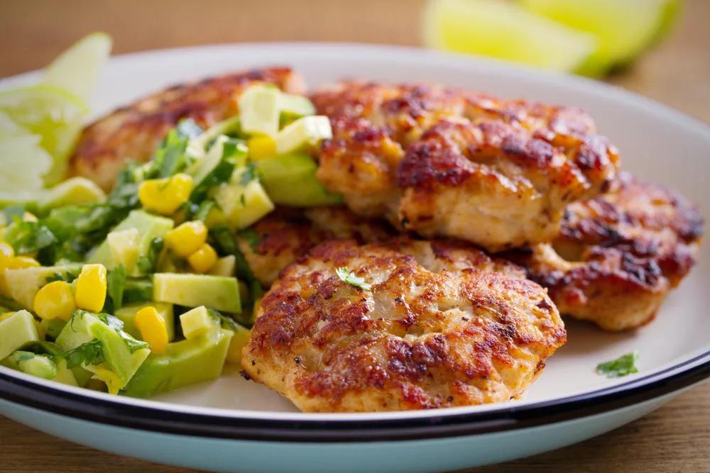Homemade,chicken,patties,or,burgers,with,avocado,corn,salsa.,horizontal