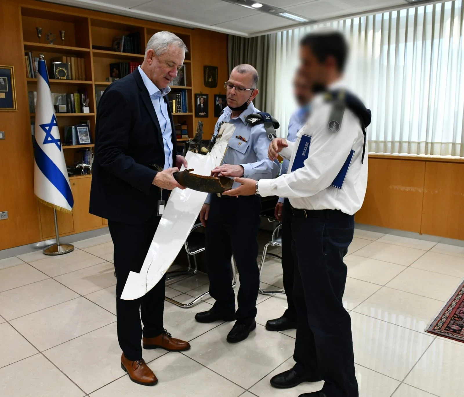שר הביטחון בני גנץ עם מפתחי המערכת, מחזיק בידיו חלקים מכלי הטיס שיורט על ידי קרן הלייזר