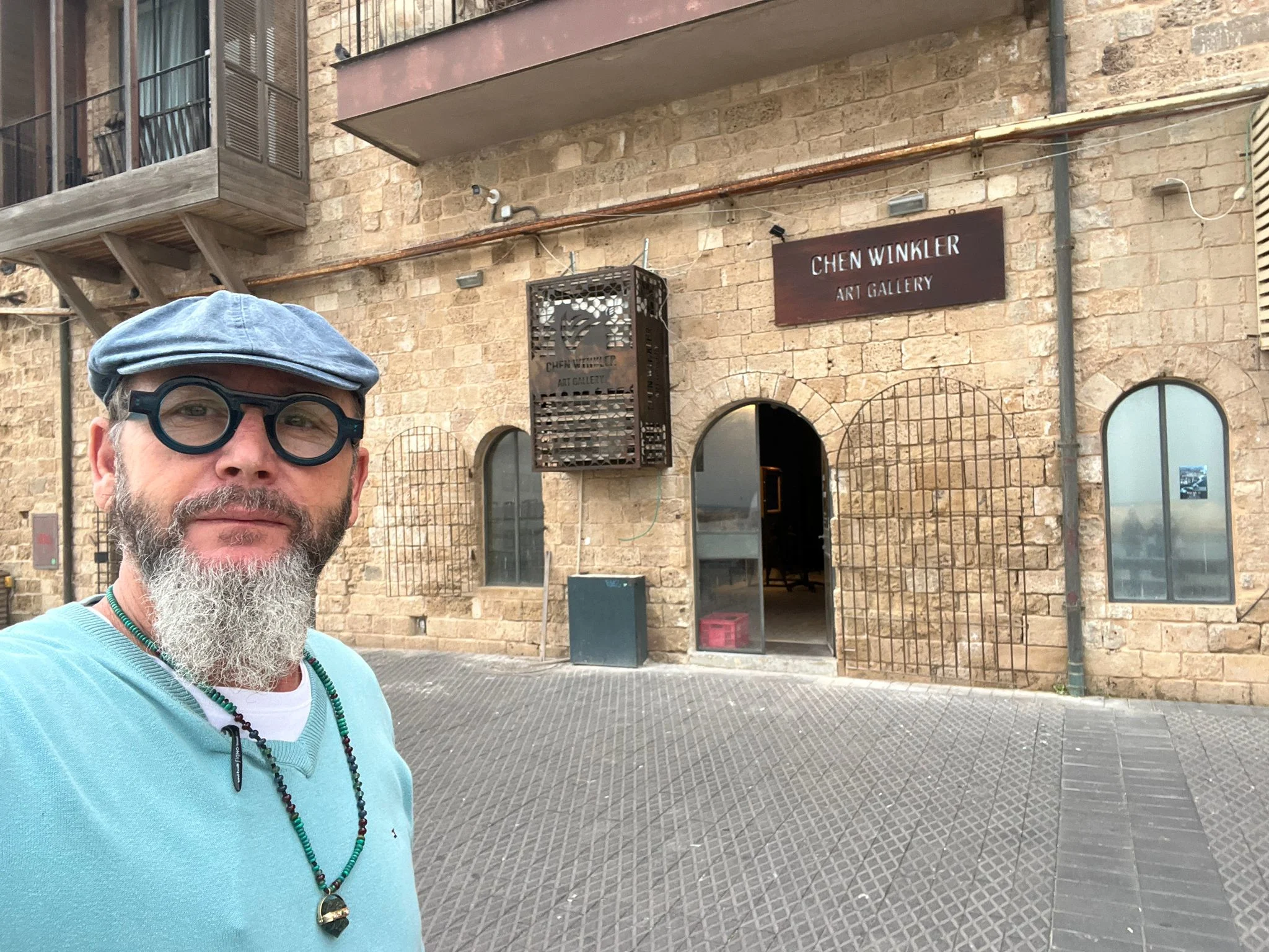 האמן חן וינקלר בפתח הגלריה שלו ביפו